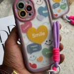 قاب موبایل آیفون لبخند قلبی محافظ لنزدار + بندست